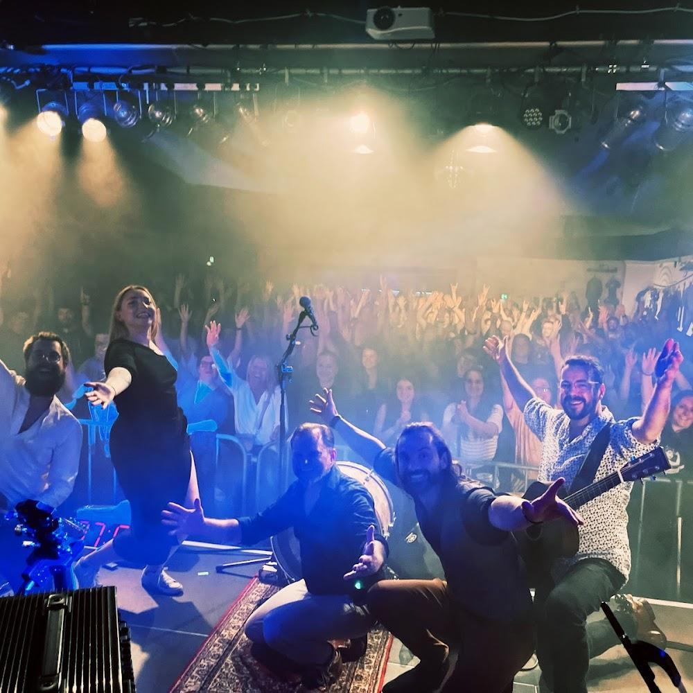A band performing on stage with a crowd.